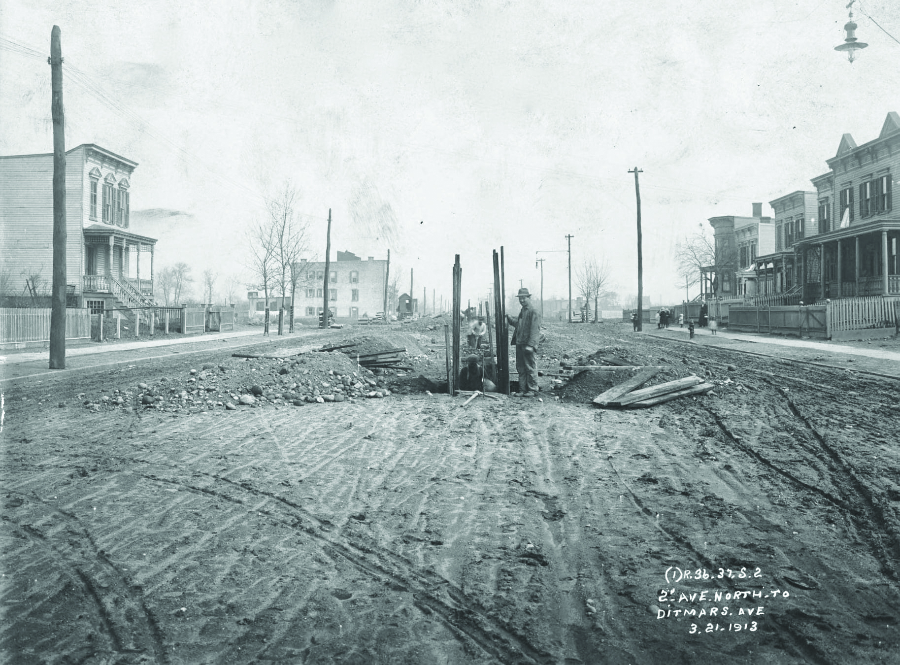 Photo Queens Historical Society: In a photo taken on March 21, 1913, we see workers digging a trench in the middle of 31st Street one block before Ditmars Boulevard in preparation for the start of construction of the elevated line.